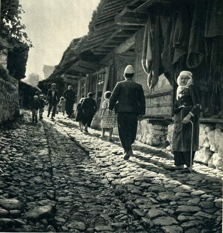 Pazari i Krujës — njerëz duke ecur nëpër rrugën me kalldrëm, veshje tradicionale