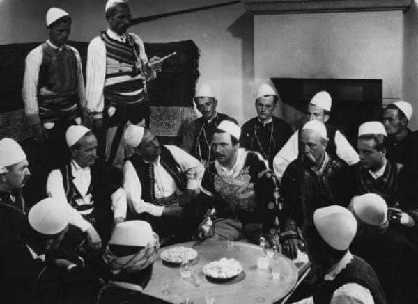 Mbledhje tradicionale — burra shqiptarë me veshje kombëtare rreth sofrit